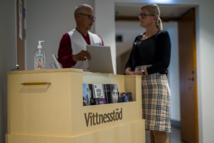 Vittnesstödjare ger information till besökare vid en domstol.