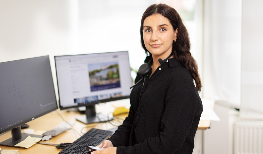 Emine Tokmak står framför sitt skrivbord